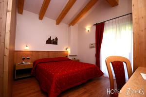 莫埃纳Hotel Zirmes的一间卧室配有红色的床和一张桌子