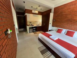 米迪加马东Coastal Hideaway的一间卧室设有一张大床和砖墙