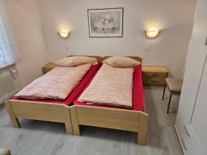 萨斯阿尔马格尔Haus Apollo的一间卧室配有两张红色床单
