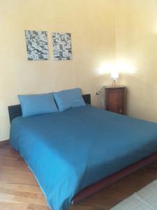 内比乌诺Casa Patrone appartamento Luigi的一张大蓝色的床,位于带灯的房间