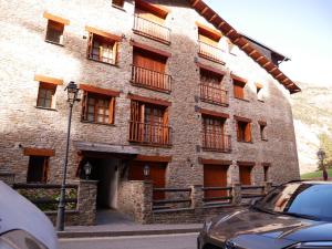 卡尼略Francoli-Vacances Pirinenca的带阳台的砖砌建筑和前方的停车场