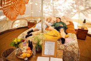 KinnulaKarkausmäki Glamping的两个人躺在帐篷里的床上