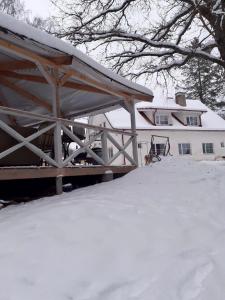 IlliVana-Vastseliina külalistemaja的前面的地面上积雪的房子