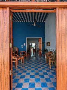 坎佩切Casa Aguazul的一间拥有蓝色墙壁的客房,地板上配有桌椅