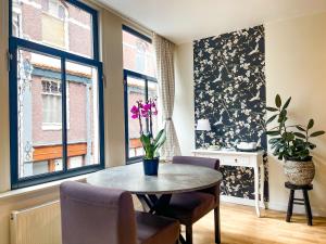 阿姆斯特丹阿姆斯特丹艺术家旅馆的一间带桌子和2个窗户的用餐室