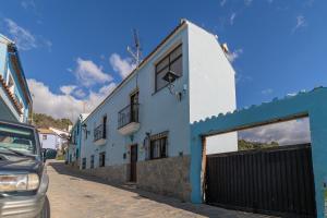 胡斯卡尔la casa del bosque的街道边的蓝色和白色建筑