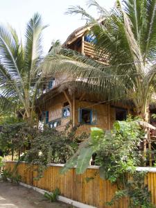 莫姆皮切Simply Paradise的围栏前有棕榈树的房子