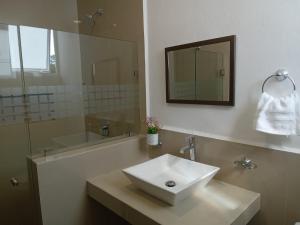 坎昆Villas Carlota Cancún的浴室设有白色水槽和镜子