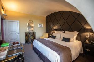 梅屈埃斯梅屈埃斯城堡酒店的一间卧室配有一张大床和大床头板