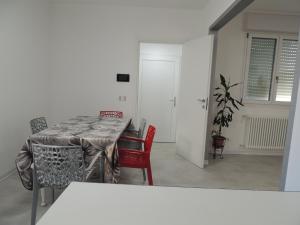 多莫多索拉Casa Cortina的一间带桌子和红色椅子的用餐室