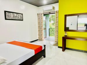 波隆纳鲁沃Aura Villa的一间卧室设有一张床和黄色的墙壁