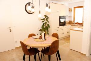 斯拉德明Riverhaus的厨房以及带木桌和椅子的用餐室。
