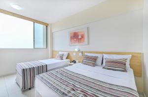 皮拉西卡巴Hotel Nacional Inn Piracicaba的一间卧室设有两张床和窗户。
