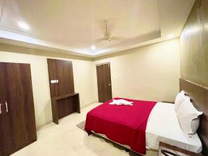 普里Hotel Janaki Pride, Puri fully-air-conditioned-hotel spacious-room with-lift-and-parking-facility的一间卧室配有一张带红色毯子的床