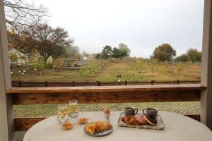 卡瓦拉HEAVEN HOUSE的一张桌子,上面放着食物,享有田野的景色