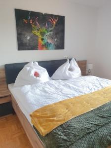 加姆利茨Appartement Gamlitz的一张铺有白色床单的床和墙上的绘画