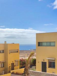 科斯塔德安提瓜Villa Costa Antigua Piscina的一座黄色的建筑,背景是大海