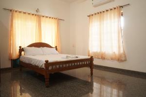 埃尔讷古勒姆Joby homestay Kadamakudy的一间卧室设有一张床和两个窗户。
