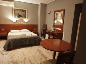 比雷埃夫斯Piraeus Acropole Hotel的酒店客房配有一张床铺和一张桌子。