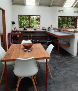 Dos BrazosCasa Bolita的一间带木桌和白色椅子的用餐室