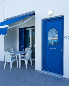 阿彻奇洛斯Stegna-TULA的大楼内带桌椅的蓝色门