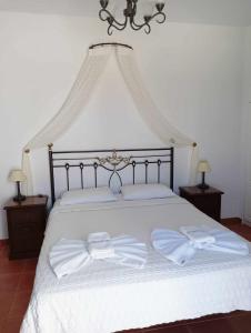 乔拉弗雷恩多斯Anemousa Hotel的一张白色的大床,上面有两条白色毛巾
