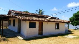 索雷Casa em Soure Ilha de Marajó.的坐在田野顶上的白色小房子