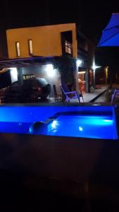 萨尔塔Casa de campo El Ceibal的夜间在房子前面的游泳池