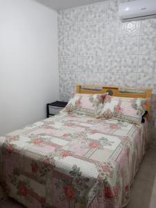 圣米格尔-杜斯米拉格里斯Casa Martins的一间卧室配有一张带花卉被子的床