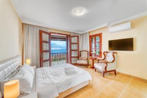 阿拉尼亚Two Seas Villa的卧室配有床、电视和椅子
