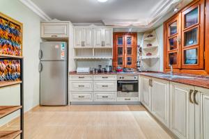 阿拉尼亚Two Seas Villa的厨房配有白色橱柜和不锈钢冰箱