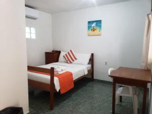 库尔克岛Beach Club Budget Rooms at Popeyes Caye Caulker的一间小卧室,配有一张床和一张书桌