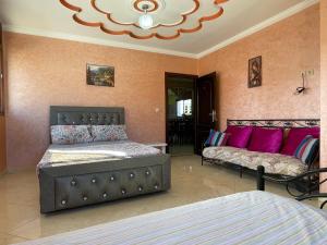依索安Villa de l'ermitage的一间卧室配有两张床和一张带粉红色枕头的沙发。
