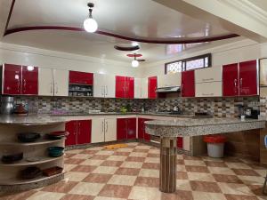 依索安Villa de l'ermitage的一间设有红色橱柜和大理石台面的厨房