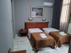 比雷埃夫斯Piraeus Acropole Hotel的一间卧室配有两张带毛巾的床