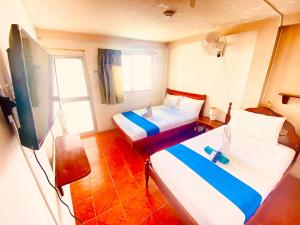阿约拉港HISTORICO HOSTAL ELIZABETH的酒店客房设有两张床和一台平面电视。