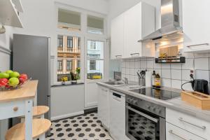不莱梅HOMEY Apartments - im Viertel mit Parkplatz的厨房配有白色橱柜和一碗水果