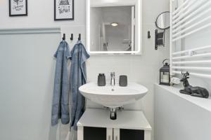 不莱梅HOMEY Apartments - im Viertel mit Parkplatz的白色的浴室设有水槽和镜子