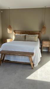 克拉罗梅科Casa claromeco的一间卧室配有一张木床和两张桌子