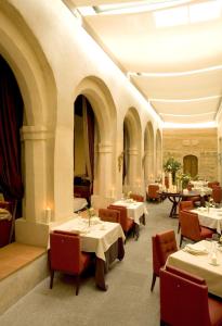 塞哥维亚圣安托尼奥皇家酒店的一间在房间内配有桌椅的餐厅