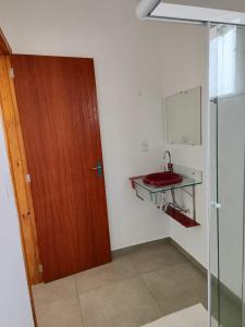 伊达贾伊Apartamento de 1 quarto próximo a 101的一间带红色水槽和玻璃门的浴室