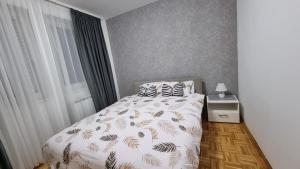萨拉热窝Aya apartment Sarajevo的卧室配有带白色棉被和枕头的床