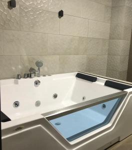 昆卡Stelar Hostal的浴室内设有一个白色浴缸及玻璃窗户