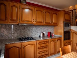 蓬他达维托亚The House of Passos的厨房配有木制橱柜和炉灶烤箱。