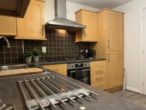 伯明翰Rooms Near Me - Central Birmingham Free Parking的厨房配有木制橱柜和炉灶烤箱。