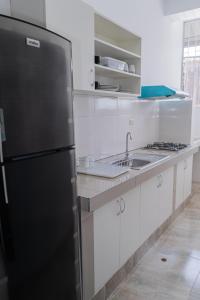 普卡尔帕Suite and Business的厨房配有黑色冰箱和水槽