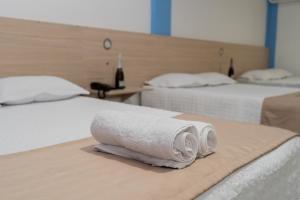 普卡尔帕Suite and Business的一间设有两张床铺和毛巾的房间