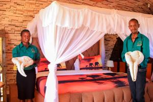 安博塞利Little Amanya Camp Amboseli的两个人站在床前