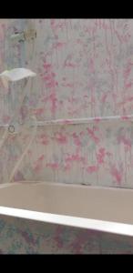 希克杜沃RM Holiday Home的带浴缸的浴室和粉红色花卉壁纸