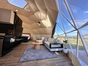克伦威尔Glamping Dome - Pinot的帐篷内的客厅,配有沙发和桌子